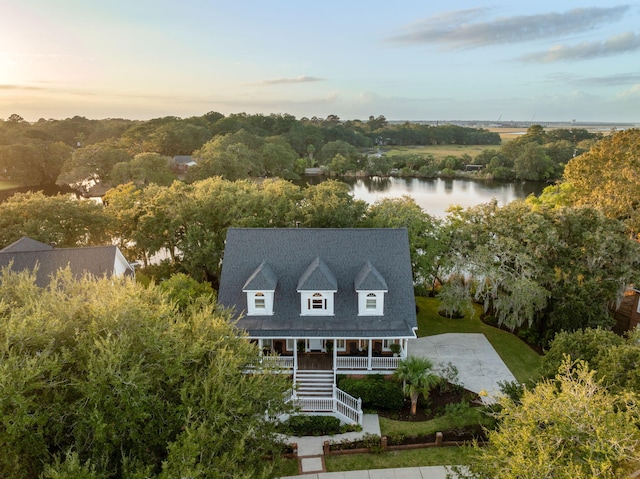 aerial view at dusk featuring a water view