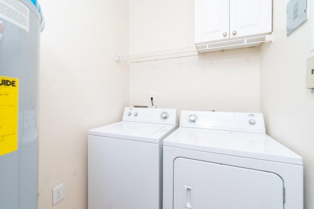 laundry area with cabinets, independent washer and dryer, and water heater