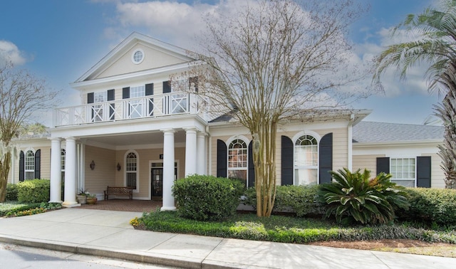 greek revival house with a balcony and covered porch