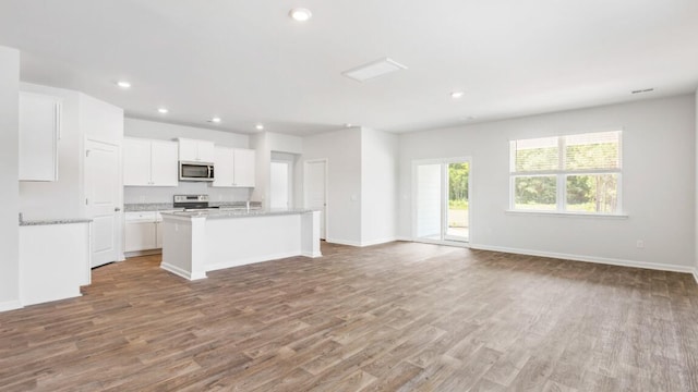 54 Twickenham Loop, Yemassee, SC 29945 - kitchen featuring stainless steel appliances, wood finished floors, white cabinetry, a kitchen island with sink, and recessed lighting