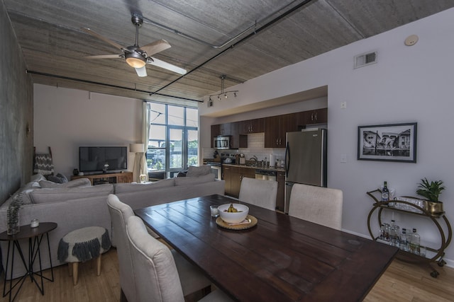 dining area featuring track lighting, ceiling fan, and light hardwood / wood-style flooring