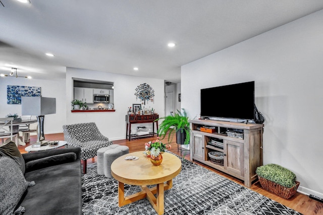 living area with recessed lighting, wood finished floors, and baseboards