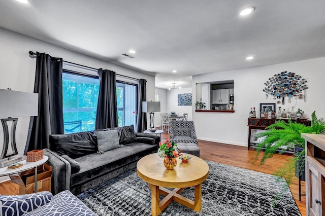 living area featuring recessed lighting, wood finished floors, visible vents, and baseboards