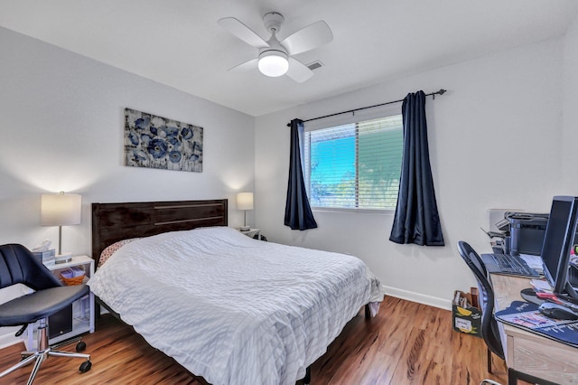 bedroom featuring visible vents, ceiling fan, baseboards, and wood finished floors