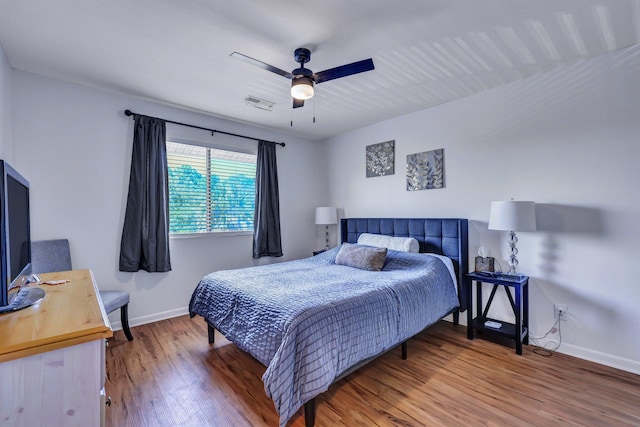 bedroom with visible vents, ceiling fan, baseboards, and wood finished floors