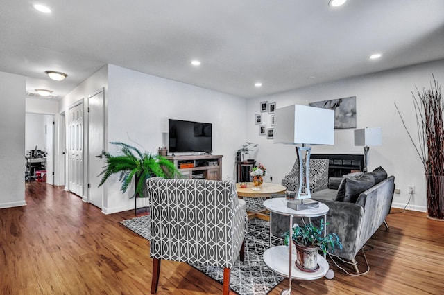 living room with baseboards, a fireplace, wood finished floors, and recessed lighting