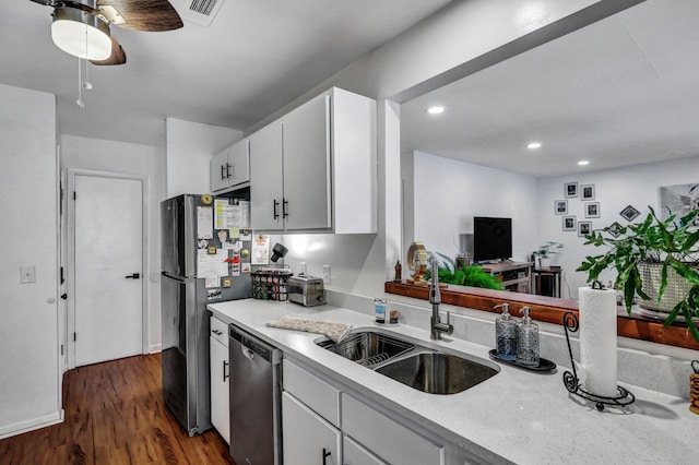 kitchen featuring dark wood-style flooring, stainless steel appliances, visible vents, white cabinetry, and a sink