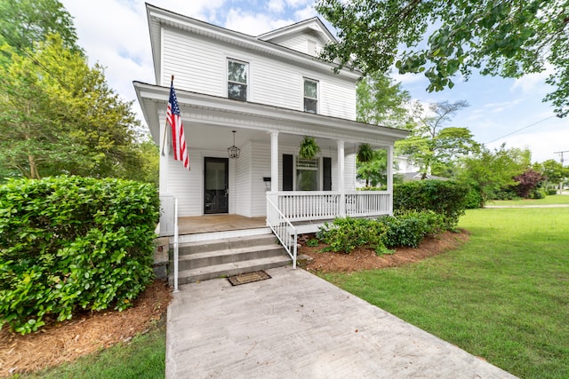 view of front of property with covered porch and a front lawn