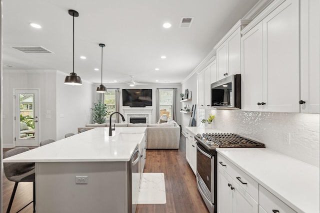 2267 Kemmerlin St, Johns Island, SC 29455 - kitchen with stainless steel appliances, a fireplace, ceiling fan, a kitchen breakfast bar, and recessed lighting