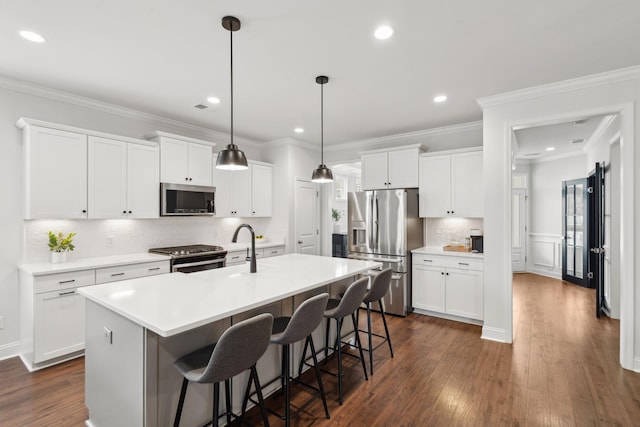 2267 Kemmerlin St, Johns Island, SC 29455 - kitchen with stainless steel appliances, a kitchen island with sink, a kitchen breakfast bar, dark wood-style flooring, and decorative backsplash