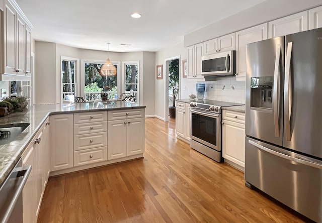 2655 Gnarled Pne, Seabrook Island, SC 29455 - kitchen with appliances with stainless steel finishes, white cabinets, light wood-type flooring, tasteful backsplash, and recessed lighting