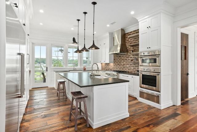 4855 Retriever Rd, Wadmalaw Island, SC 29487 - kitchen featuring high end appliances, a warming drawer, dark countertops, wall chimney range hood, and a sink