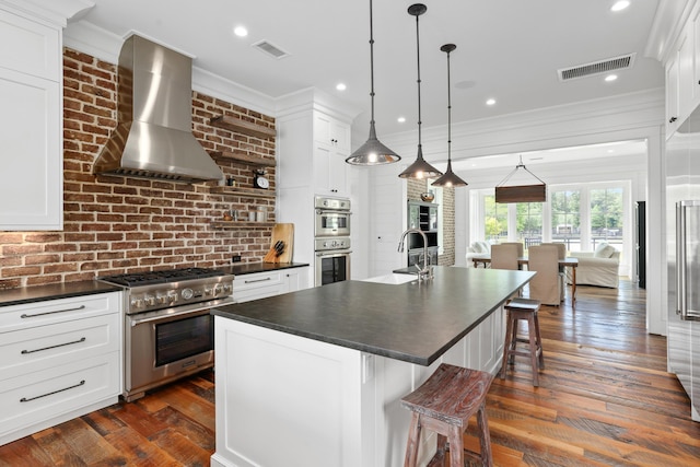 4855 Retriever Rd, Wadmalaw Island, SC 29487 - kitchen featuring wall chimney exhaust hood, dark countertops, stainless steel appliances, a sink, and crown molding