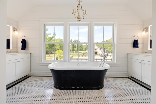 4855 Retriever Rd, Wadmalaw Island, SC 29487 - bathroom featuring vaulted ceiling, two vanities, a freestanding tub, and wood walls
