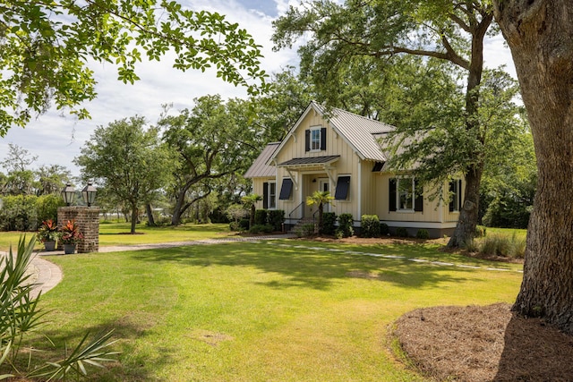 4855 Retriever Rd, Wadmalaw Island, SC 29487 - view of front of home featuring board and batten siding, a front yard, a standing seam roof, and metal roof