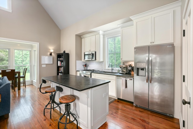 4855 Retriever Rd, Wadmalaw Island, SC 29487 - kitchen with stainless steel appliances, dark countertops, a sink, a breakfast bar area, and white cabinets