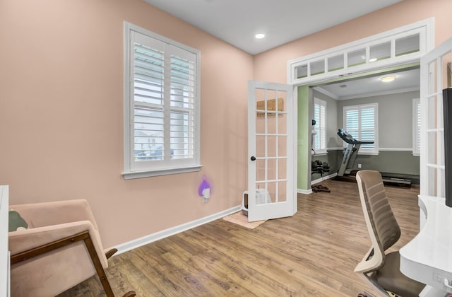 office featuring french doors, light wood-type flooring, and crown molding