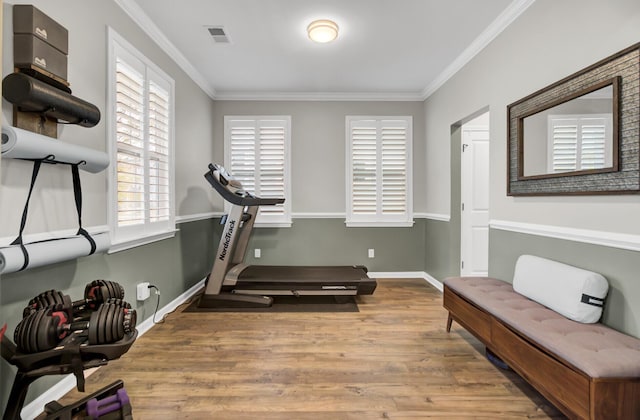 workout room with crown molding and light hardwood / wood-style floors