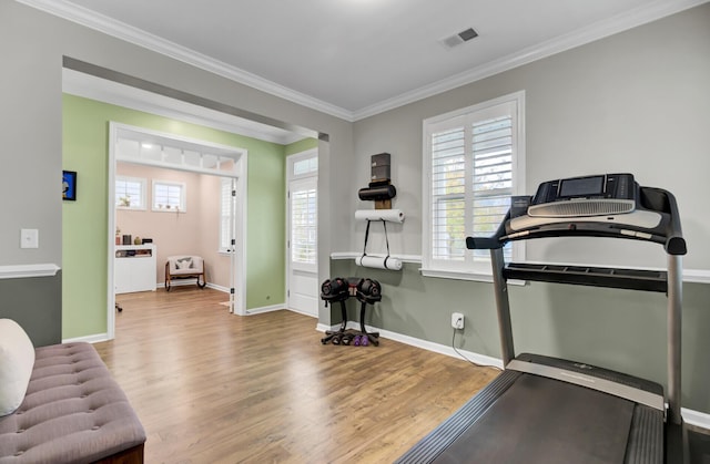 exercise area featuring light hardwood / wood-style floors and ornamental molding