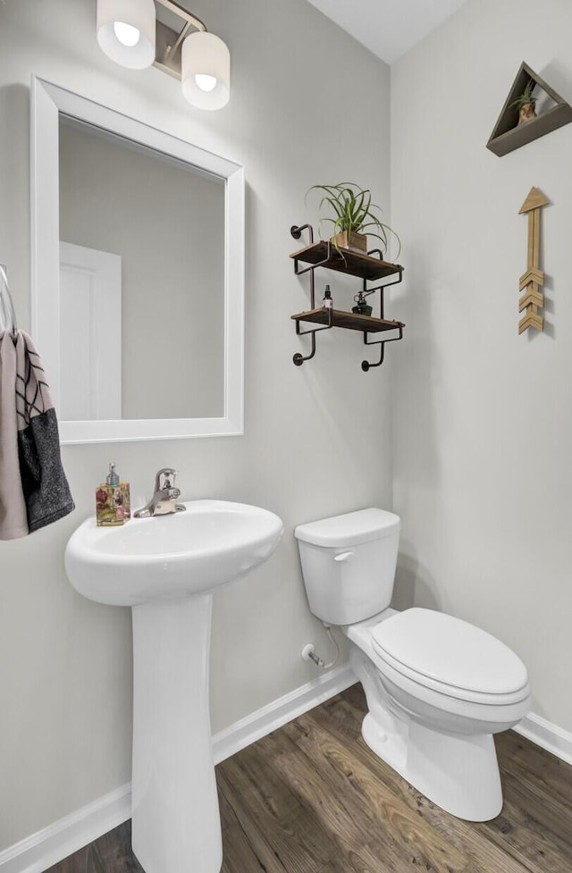 bathroom with hardwood / wood-style flooring, toilet, and sink