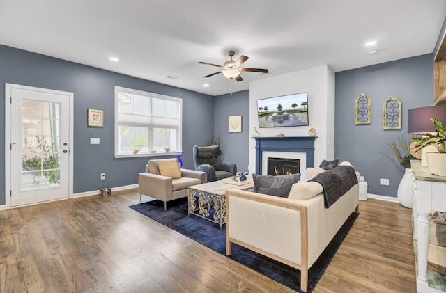 living room featuring ceiling fan and dark hardwood / wood-style flooring