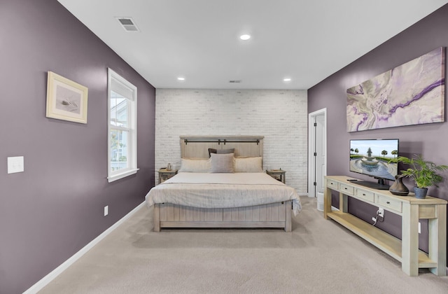 carpeted bedroom featuring brick wall