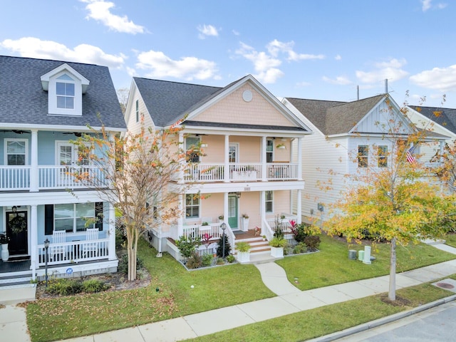 view of front of home with a balcony and a front yard