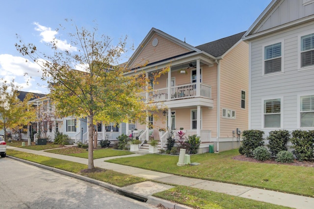 view of front of property with covered porch, a balcony, and a front lawn