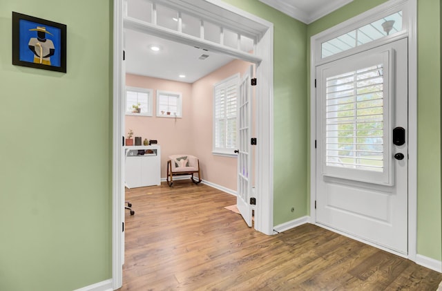 entryway with hardwood / wood-style floors and crown molding