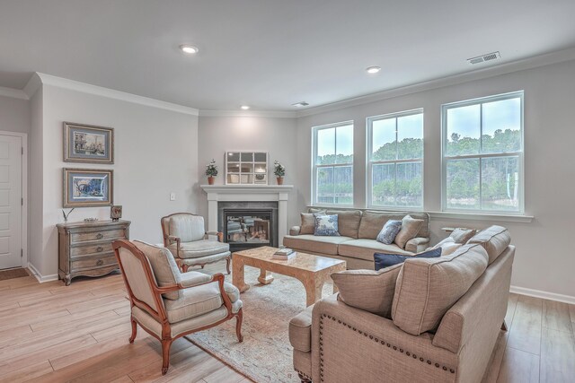 living room featuring crown molding, a wealth of natural light, and light wood-type flooring