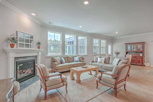 living room with ornamental molding, plenty of natural light, and light wood-type flooring