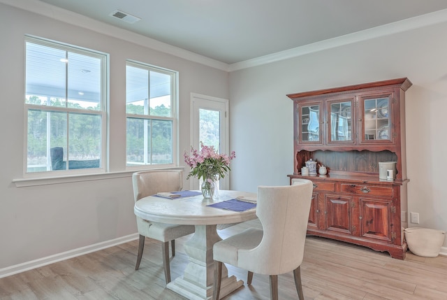 dining space featuring ornamental molding and light hardwood / wood-style floors