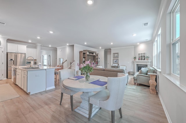 dining room featuring crown molding and light wood-type flooring