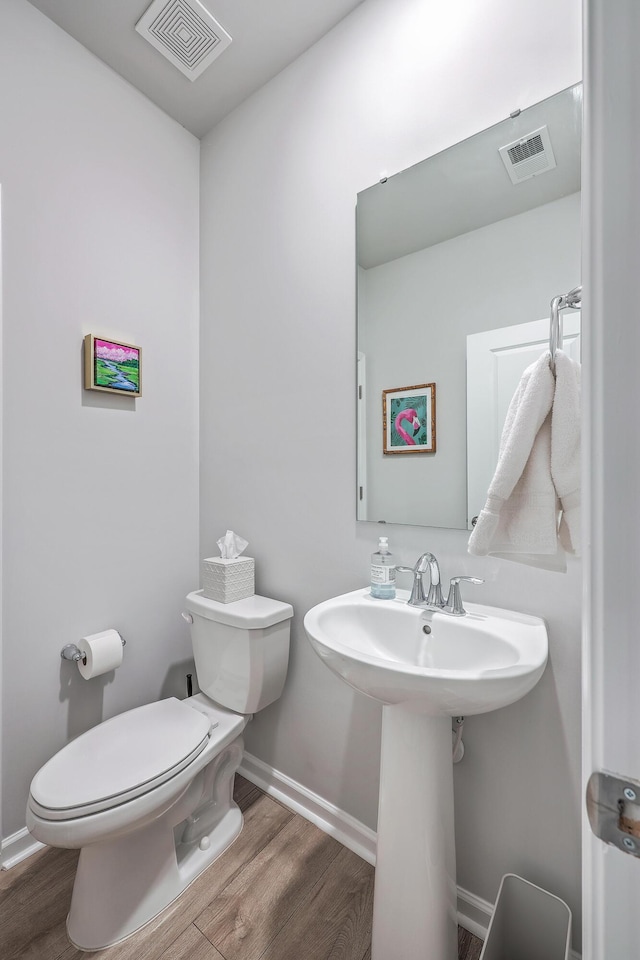 bathroom featuring hardwood / wood-style flooring and toilet