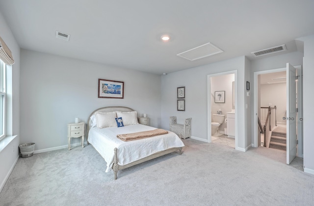 bedroom featuring connected bathroom and light carpet