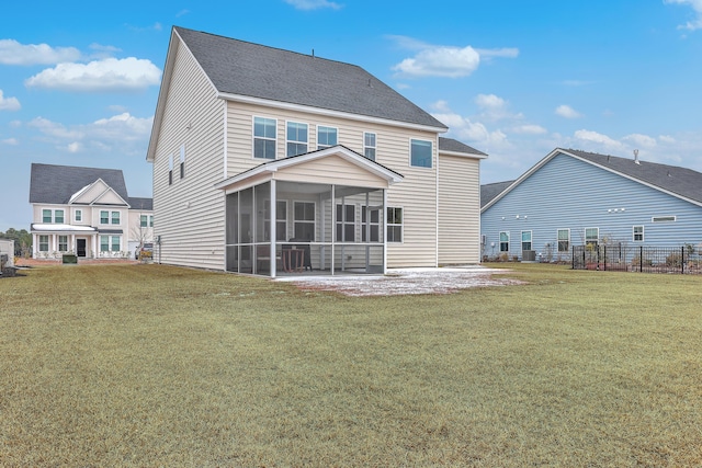 back of property with a patio area, a sunroom, and a lawn