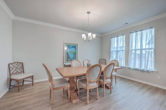 dining room with an inviting chandelier, ornamental molding, and light hardwood / wood-style flooring