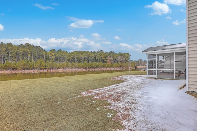 view of yard featuring a patio area, a sunroom, and a water view