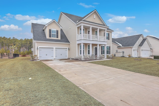 greek revival inspired property with a balcony, a garage, a porch, and a front yard