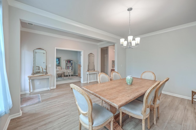 dining area with a notable chandelier, ornamental molding, and light wood-type flooring