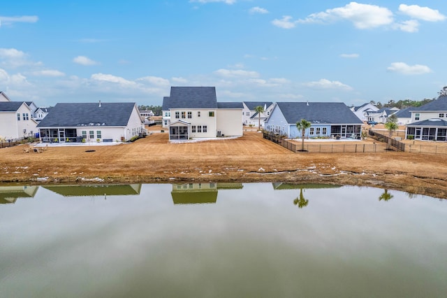 rear view of house with a yard and a water view