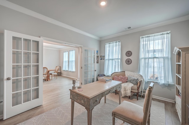 office space featuring crown molding, light wood-type flooring, and french doors