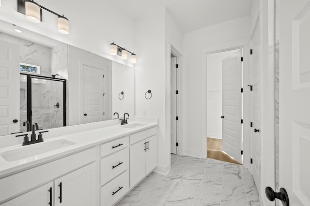 bathroom with marble finish floor, a sink, a marble finish shower, and double vanity