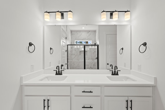 bathroom featuring double vanity, a marble finish shower, and a sink