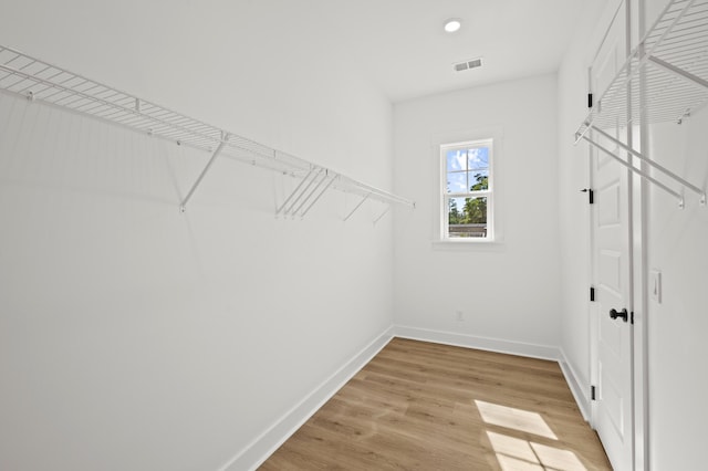 walk in closet with light wood finished floors and visible vents