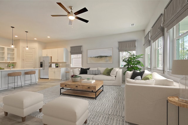 living area featuring a ceiling fan, light wood-type flooring, visible vents, and recessed lighting