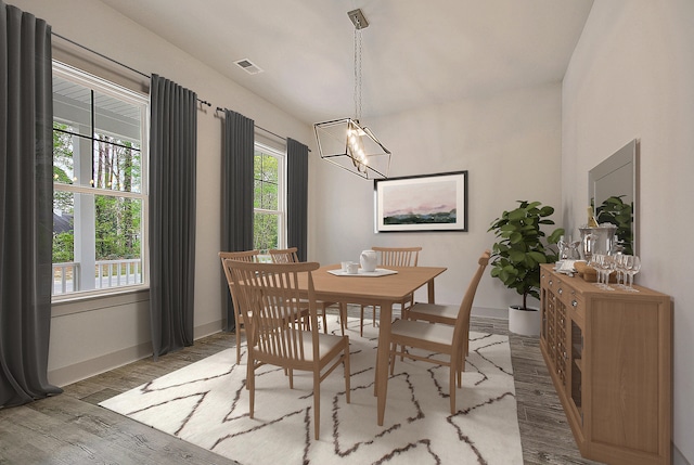 dining space featuring light wood finished floors, an inviting chandelier, visible vents, and baseboards