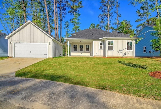 view of front facade featuring driveway, a front lawn, and board and batten siding