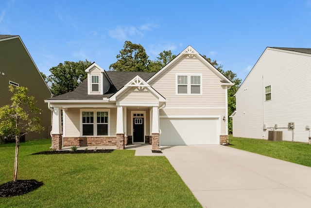 craftsman house featuring a garage, central AC, a front lawn, concrete driveway, and stone siding