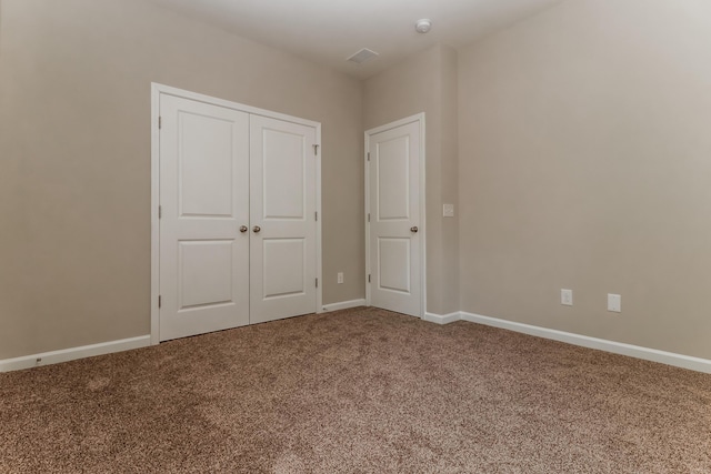 unfurnished bedroom featuring carpet floors, baseboards, and a closet